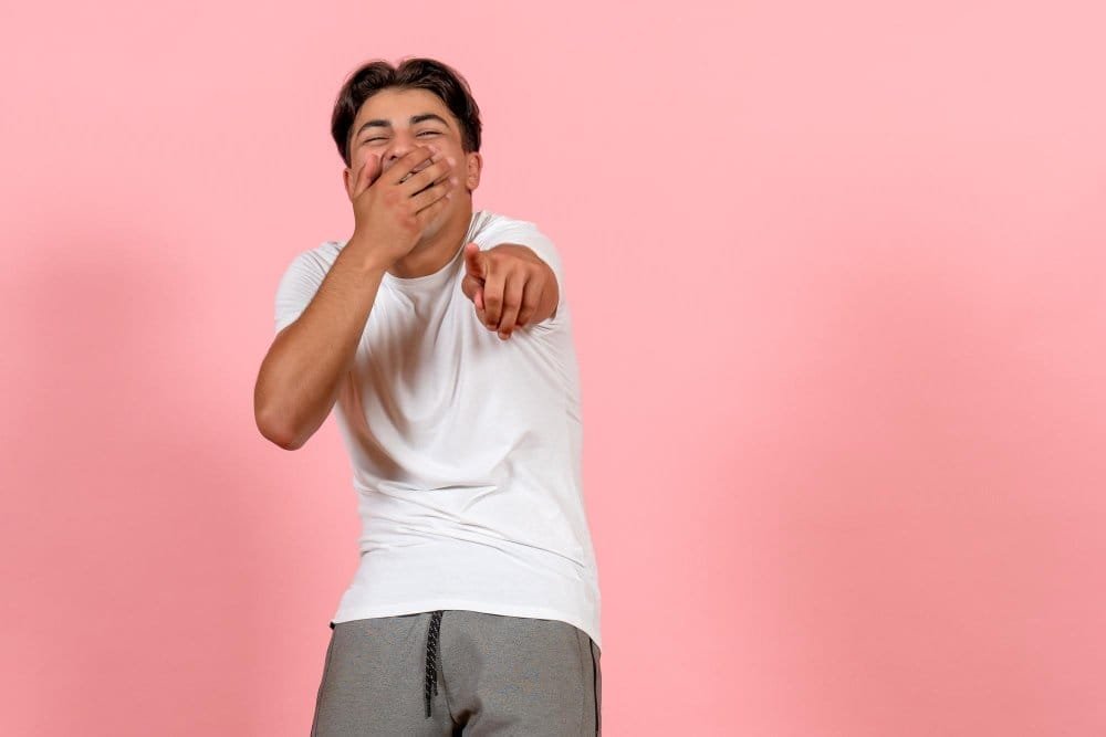 front view young male laughing white t shirt pink background