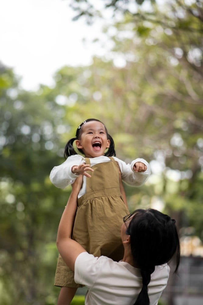 medium shot mother holding girl outdoors