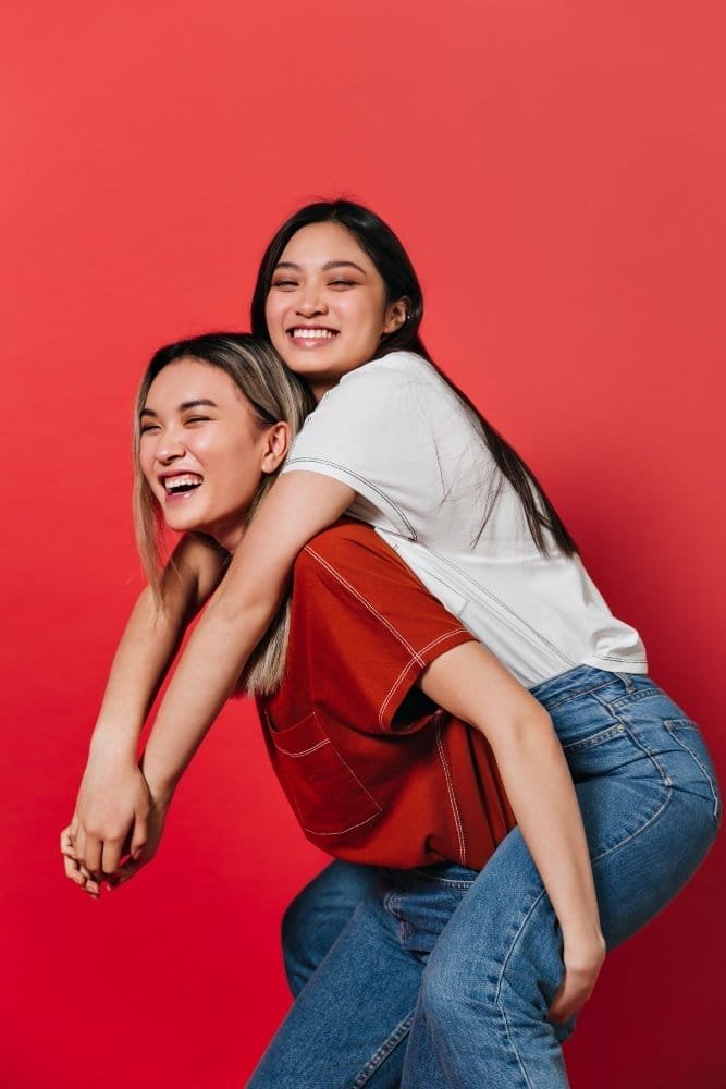 women having fun red wall
